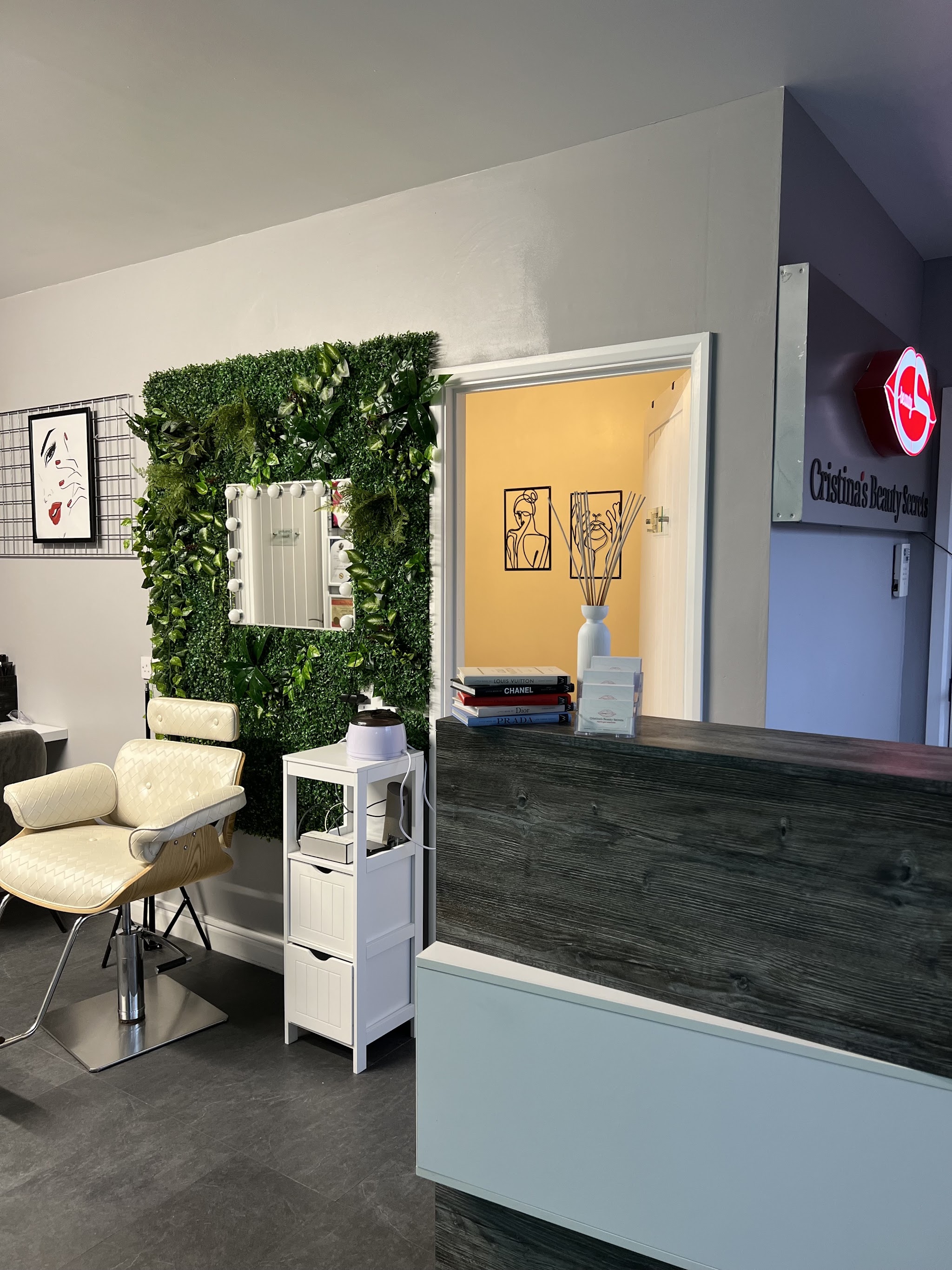 Reception at Cristina's Beauty Secrets with the illuminated red lips sign on the wall